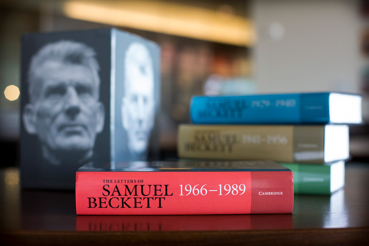 Colorful stack of several covers of books by Samuel Becket, one cover (somewhat out of focus) with a black-and-white portrait of Becket. 