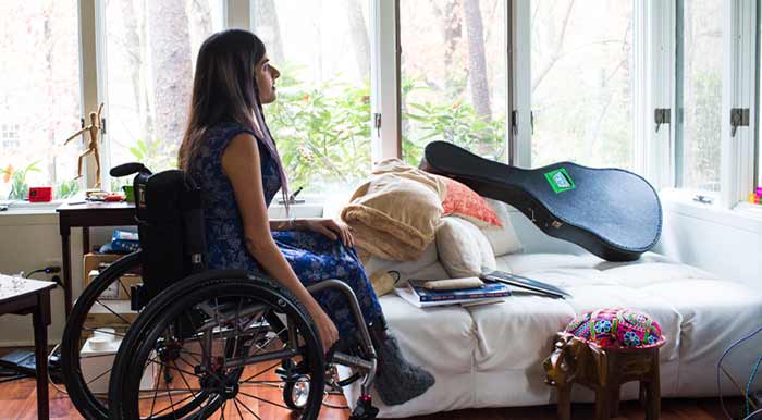 student sitting in a wheelchair in her residence hall room