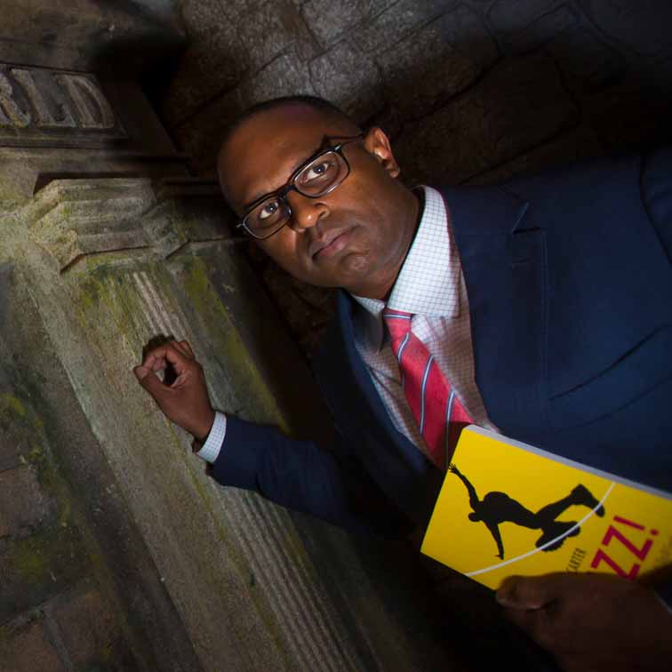 Oxford psychology professor Ken Carter holding a yellow-covered book in a scary, dark place